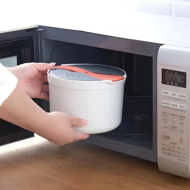 White microwave-safe rice cooker with a black and orange lid featuring a silicone grip designed for steaming and straining rice with a two-liter capacity.