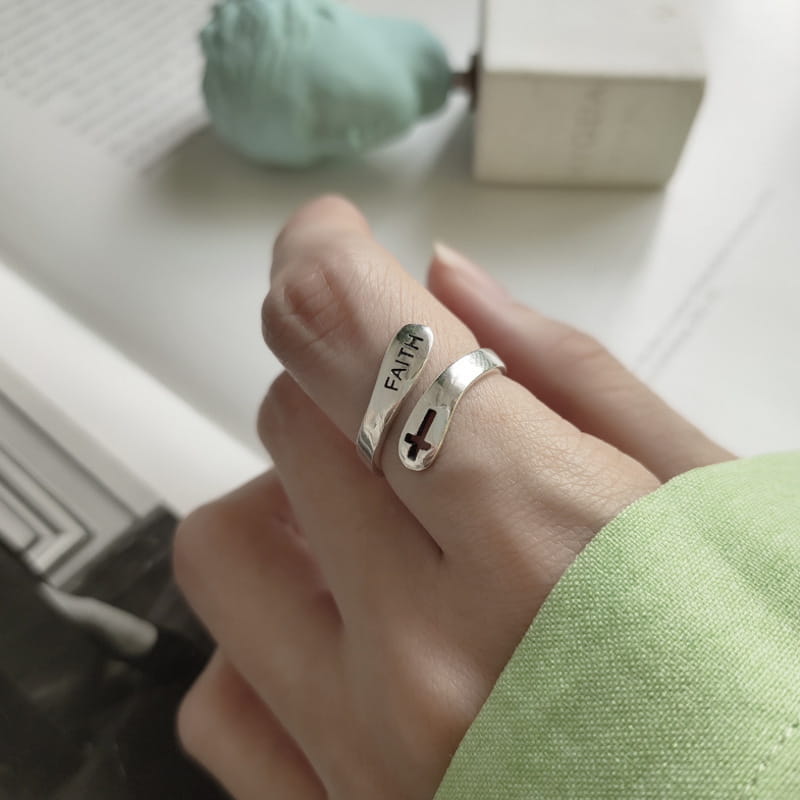 Silver faith cross wrap ring with adjustable band featuring an engraved faith inscription and cross design on a polished silver wrap-around band.