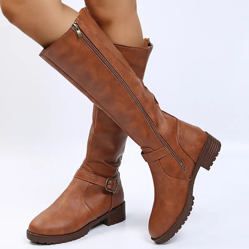 Tan leather knee high knight boots with a buckle strap and zipper closure.
