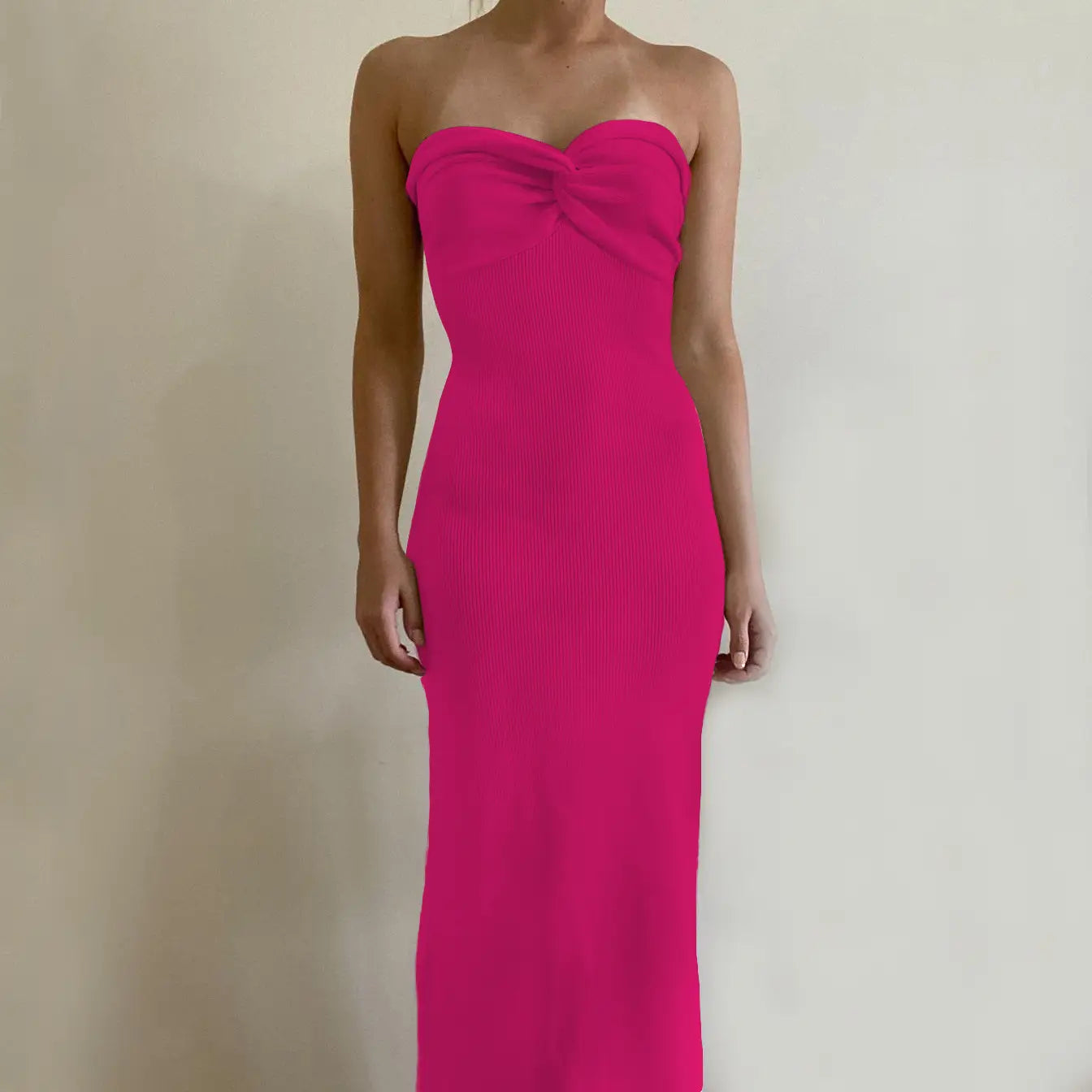 A vibrant fuchsia off shoulder knotted ribbed knit midi dress with a strapless design and sweetheart neckline.