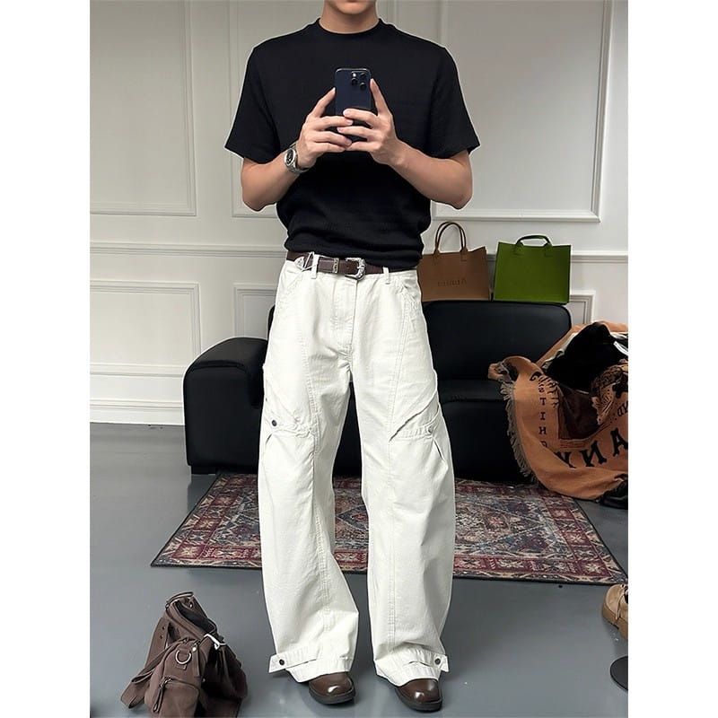 White wide-leg cargo pants featuring multiple pockets and buttoned cuffs made from durable fabric for functional and stylish wear.