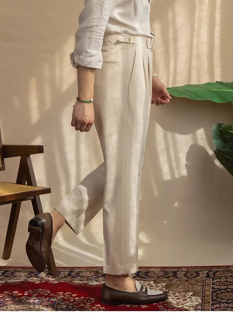 Cream-colored men’s slim fit linen suit trousers with a tailored fit and pleated front ideal for summer wear.
