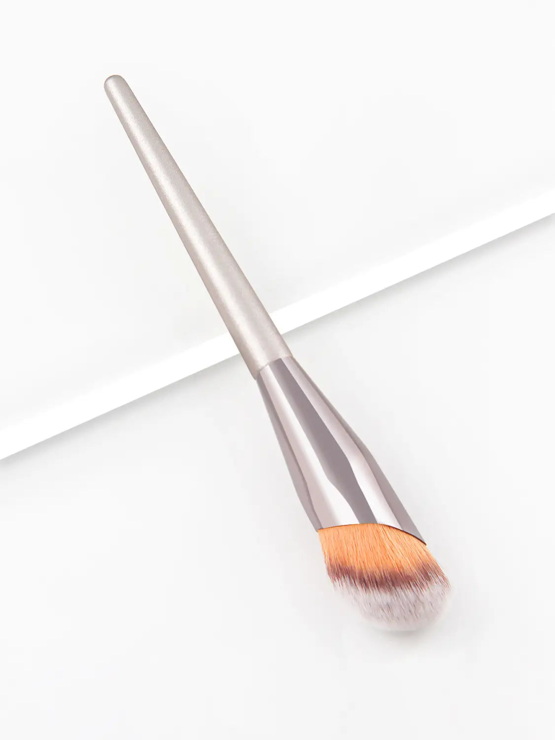 A sleek metallic silver finger belly makeup brush with a tapered handle and soft gradient orange to white bristles designed as a professional contour tool.