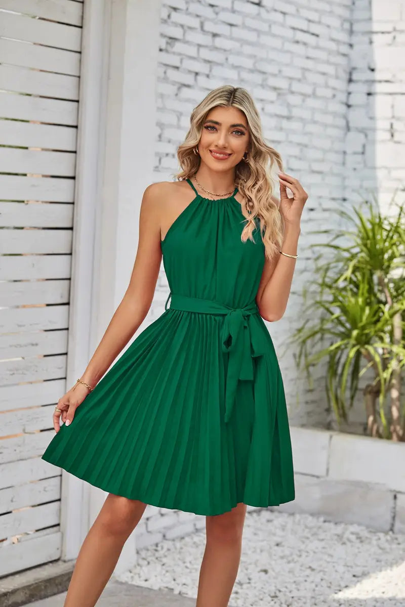 A vibrant emerald green halter neck pleated chiffon mini dress with a matching belt tied at the waist.