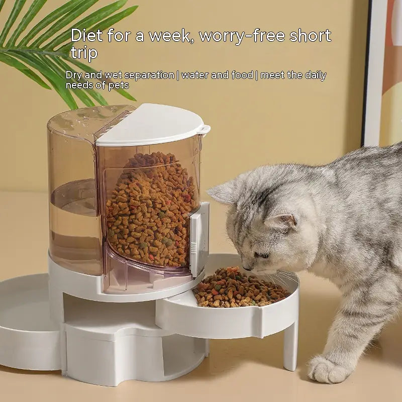 Alimentador automático para mascotas con dos cuencos y dispensador de agua, con cuerpo de plástico blanco y traslúcido y bandeja giratoria que dispensa pienso seco.