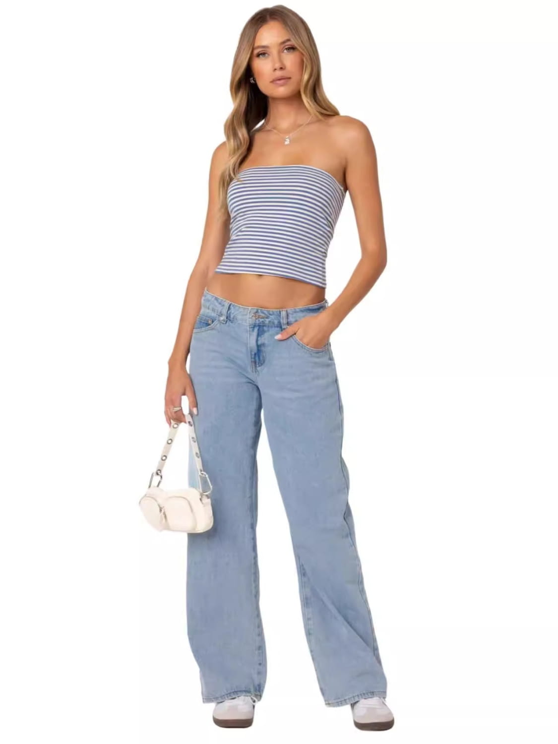 a white crossbody bag with a chain strap and rounded compact design paired with high waist wide leg denim jeans