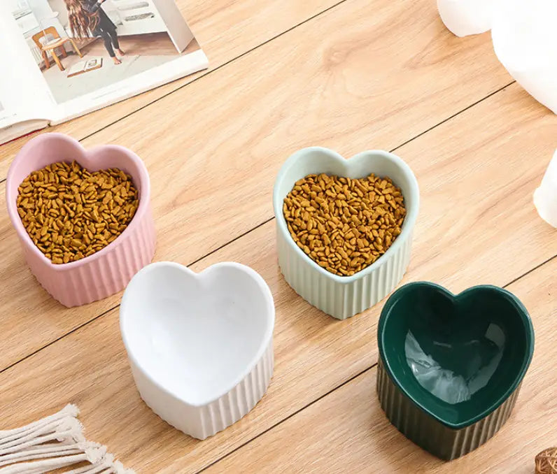 Tilted ceramic cat bowl set 4 pack featuring pink white and green heart-shaped pet food bowls with vertical ridged sides.