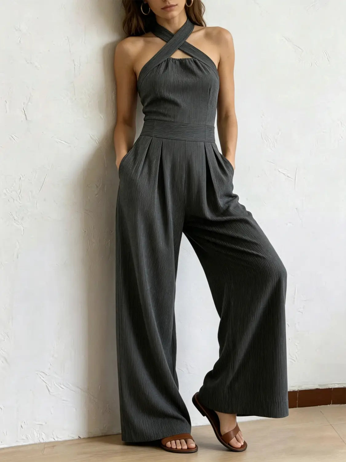 Ein eleganter dunkelgrauer gerippter Halterneck-Jumpsuit mit geschlossener Front-Ausschnittpartie und Hosen im weitem Bein.
