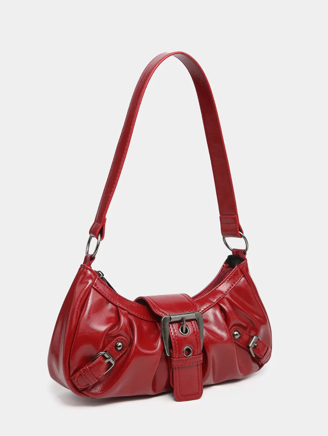 A vintage leather shoulder bag in glossy red faux leather with a curved design and silver-toned metal buckle details.