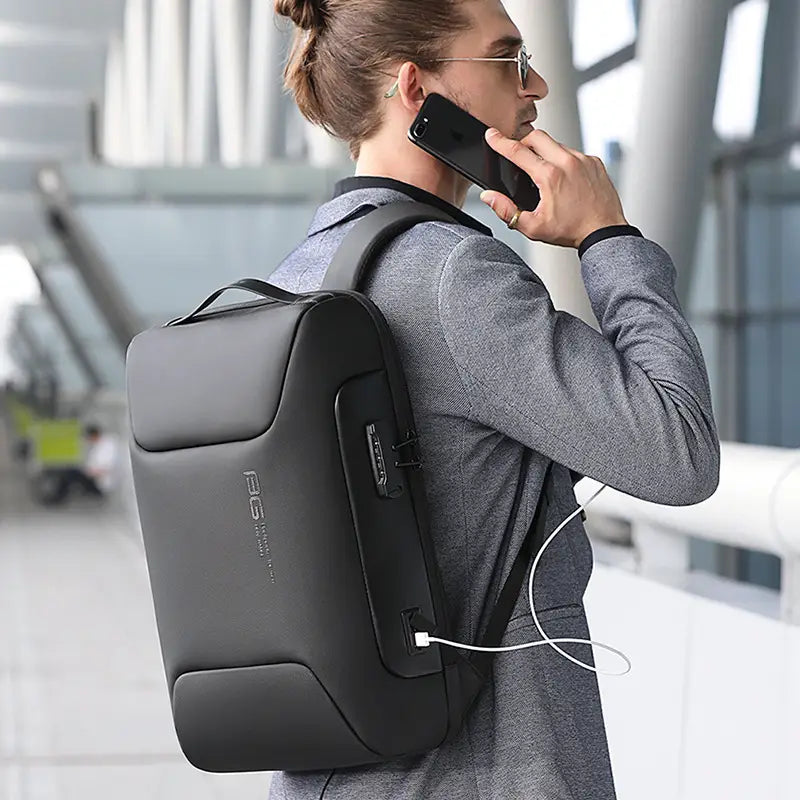 Schwarzer, eleganter, wasserdichter Business-Laptop-Rucksack mit einem vorderen Reißverschlussfach und USB-Ladeanschluss für eine bequeme Verbindung der Geräte.