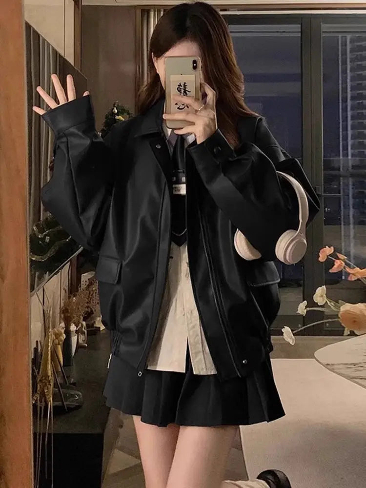 Black faux leather bomber jacket with oversized sleeves and front pockets in a short coat design.