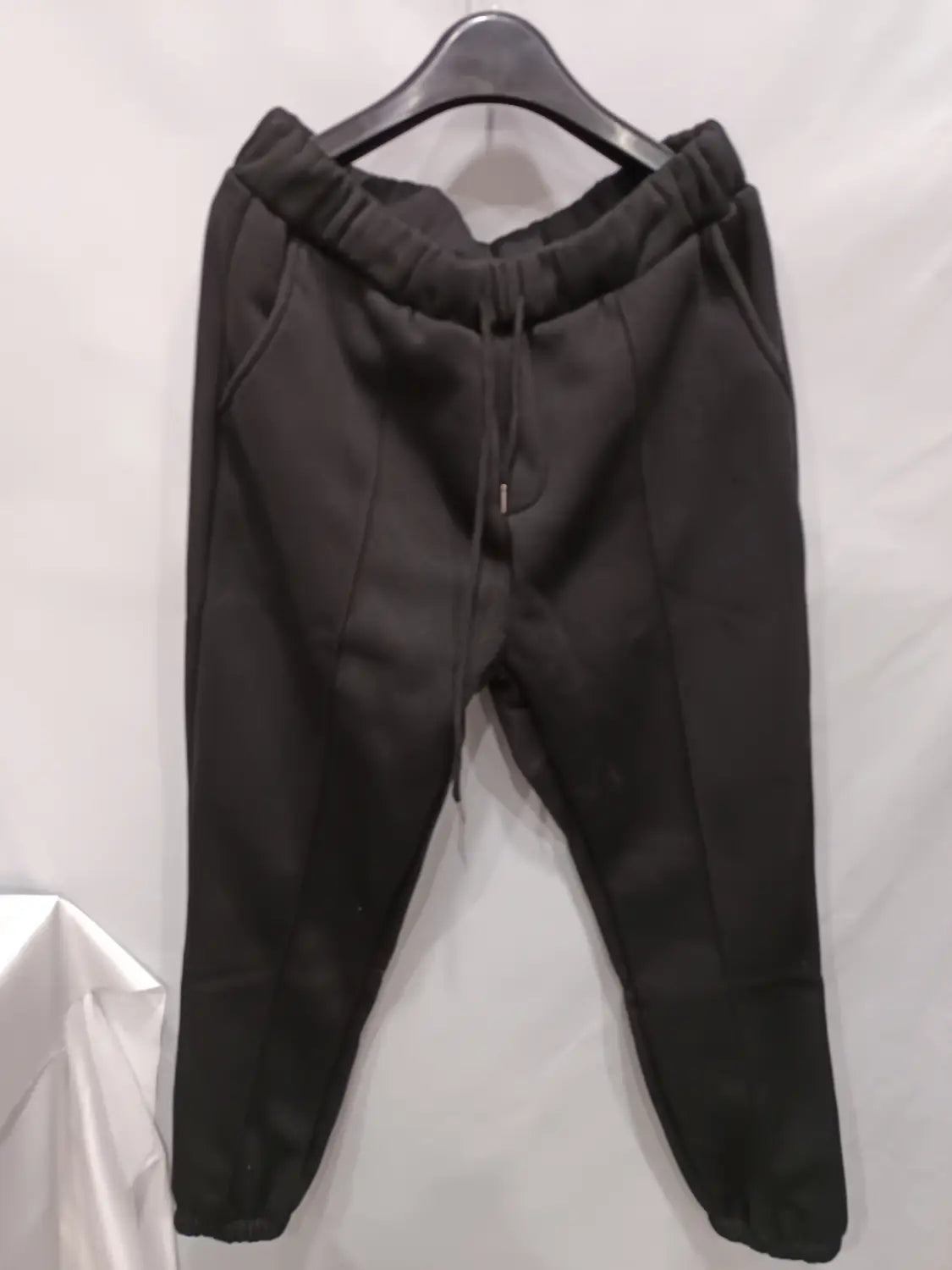 men’s black fleece drawstring sweatpants with elastic waistband and tapered legs shown from the back side