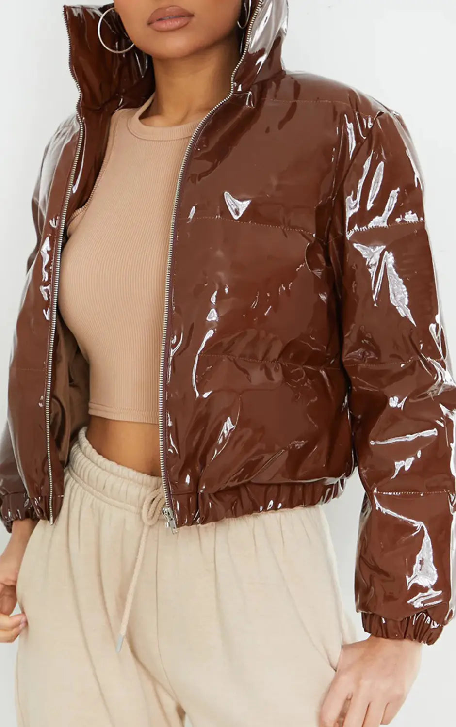 A shiny brown glossy puffer jacket short cotton padded for women with a hood designed to keep warm.