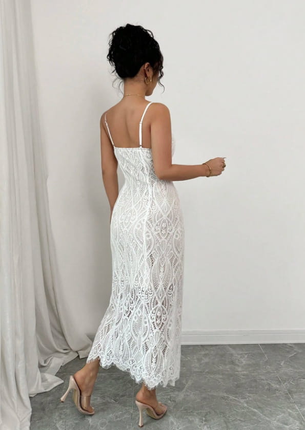 A white floral lace v neck maxi dress with delicate intricate patterns thin spaghetti straps and a side slit.