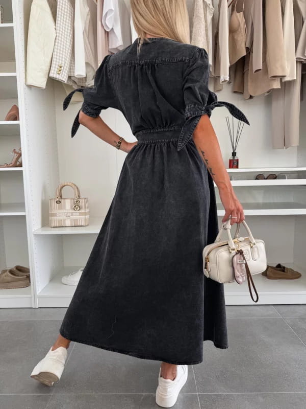 Black denim midi dress with button front, short puffed sleeves tied at the cuffs, and a fitted waistband.