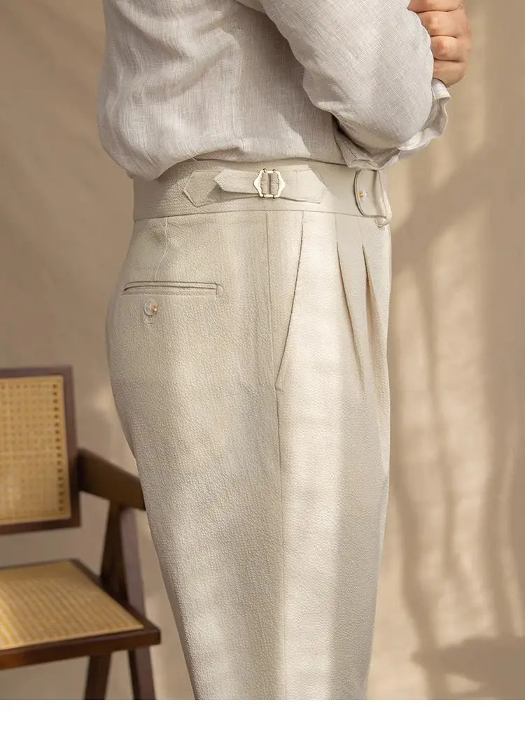 Light beige men’s slim fit pleated summer linen suit trousers with a matching belt and subtle texture.