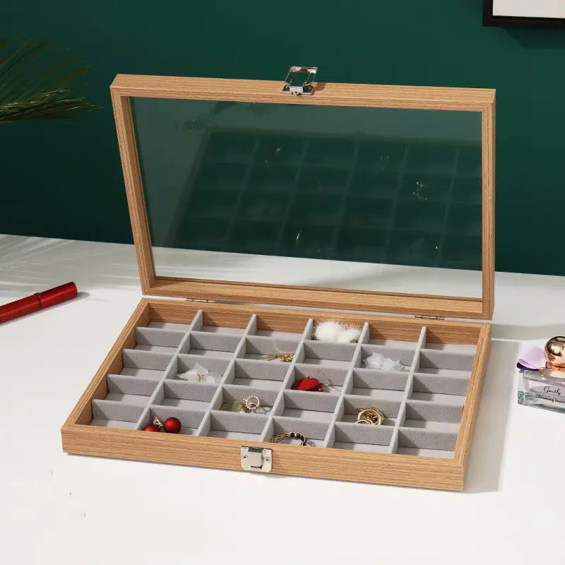 Rosewood jewelry display box featuring a light wood finish, rectangular shape, glass lid, and gray felt-lined compartments for organized storage.