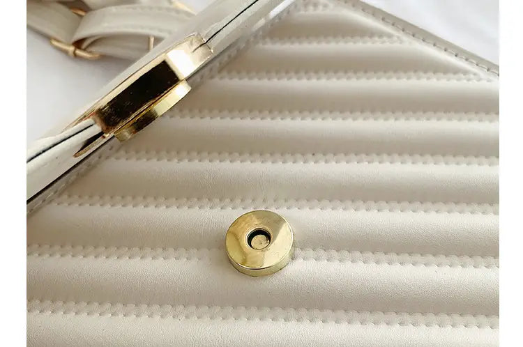 A cream-colored quilted leather clutch with gold-tone hardware and a sleek structured design from the Quilted Heart Clasp Crossbody Bag with Ruched Handle collection.