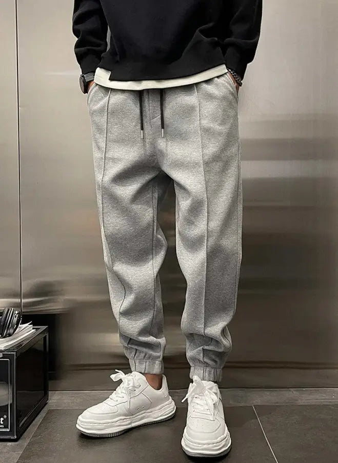Men’s fleece drawstring sweatpants in gray heathered color with a drawstring waist and elastic cuffs made from soft fleece material.