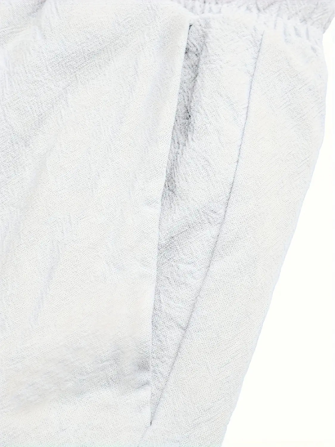 Pantalon décontracté en lin pour hommes avec tissu blanc texturé présentant un motif tissé subtil et une ceinture élastique pour une coupe ample.