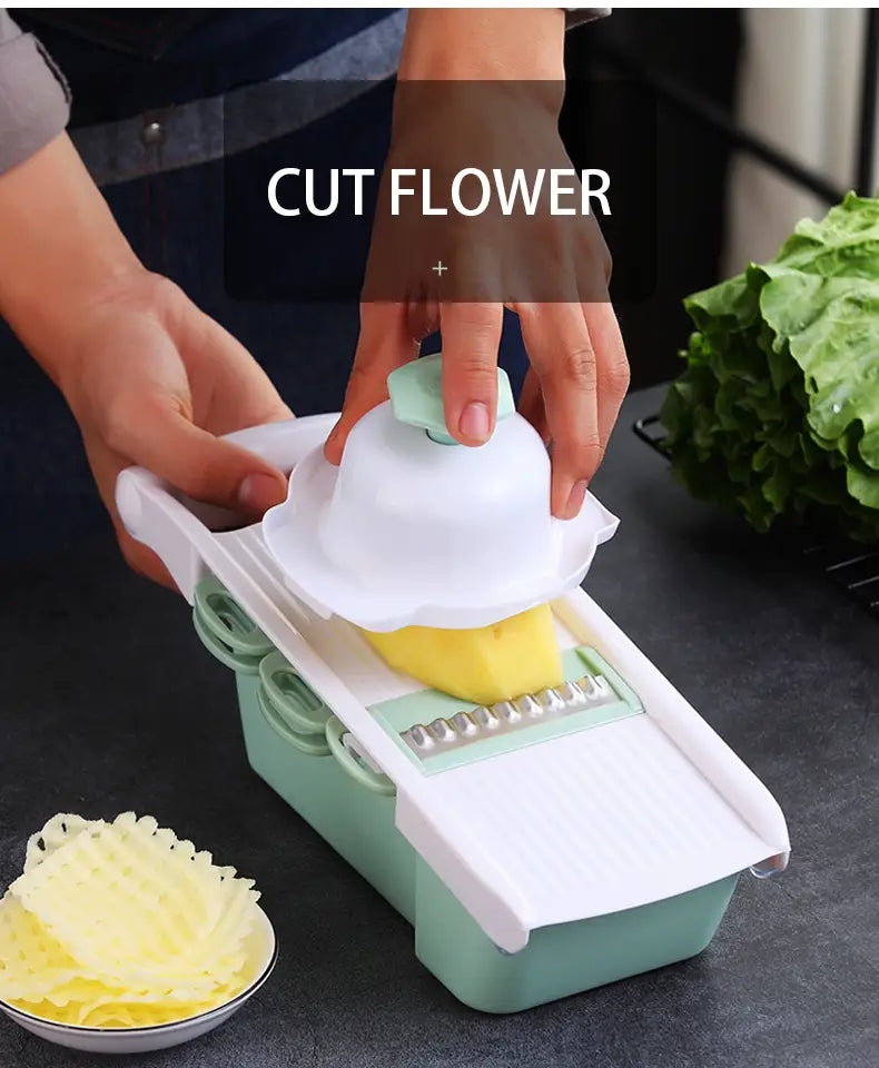 A mint green and white vegetable slicer mandoline grater with blades and a curved handle designed for slicing fruits or vegetables into thin strips.