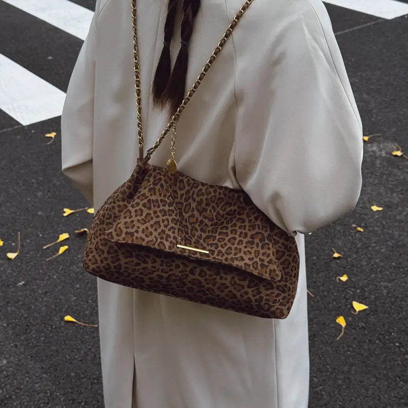 Brown leopard print crossbody bag featuring a gold chain strap and metallic clasp for stylish shoulder wear.