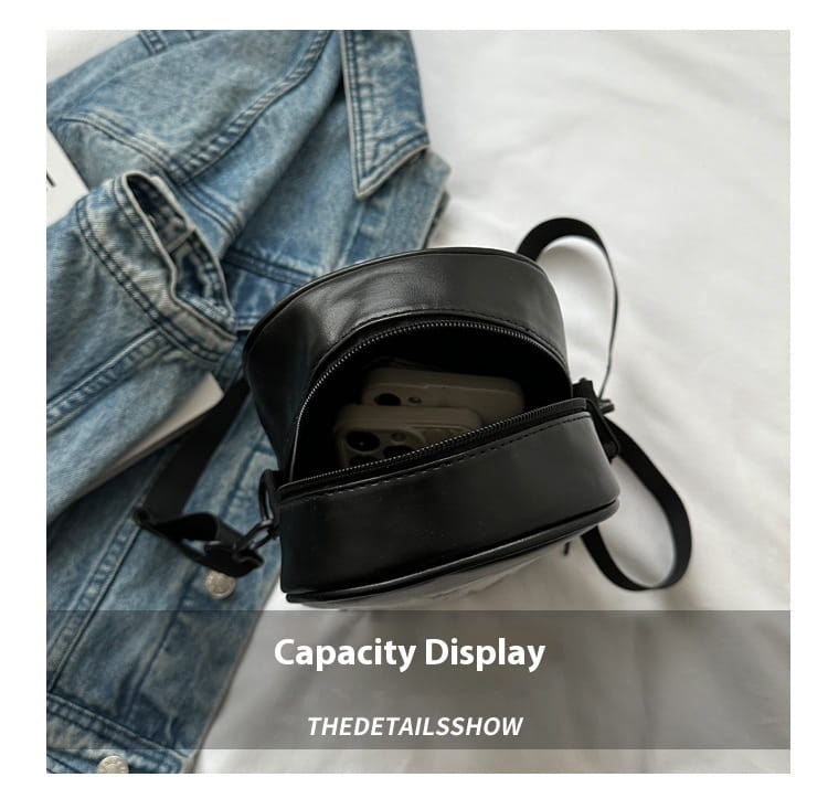 black circular crossbody bag with smooth leather-like finish and adjustable strap from embroidered Halloween floral and pumpkin crossbody bags collection.