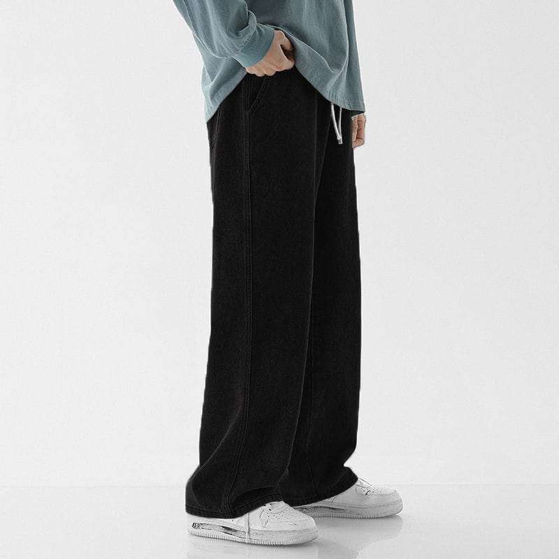 Black relaxed fit drawstring wide leg denim jeans with visible side seam stitching.