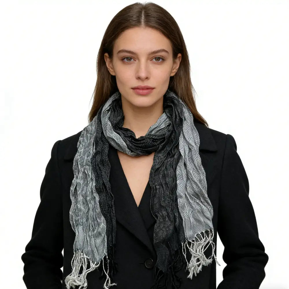 Écharpe longue d’hiver en polyester jacquard gris pour femmes, avec un motif dégradé texturé gris et noir et des bords effilochés.