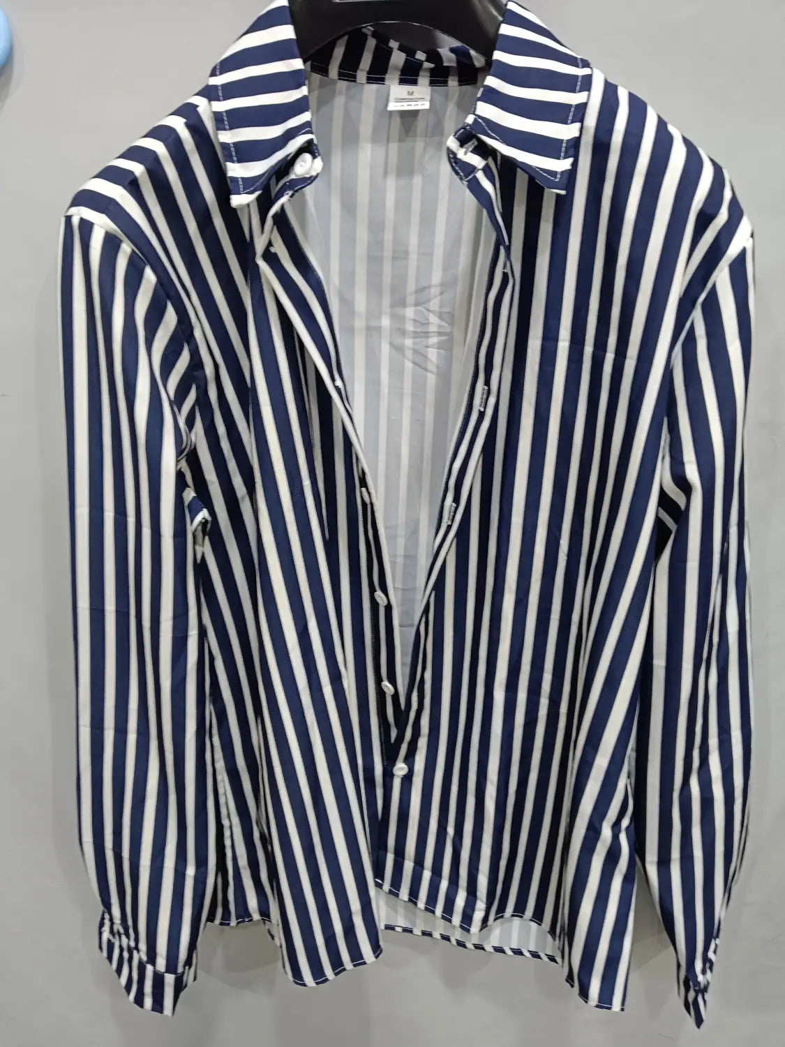 Chemise décontractée à manches longues rayée verticalement bleu marine et blanc pour hommes, avec col classique et finition de tissu soignée.
