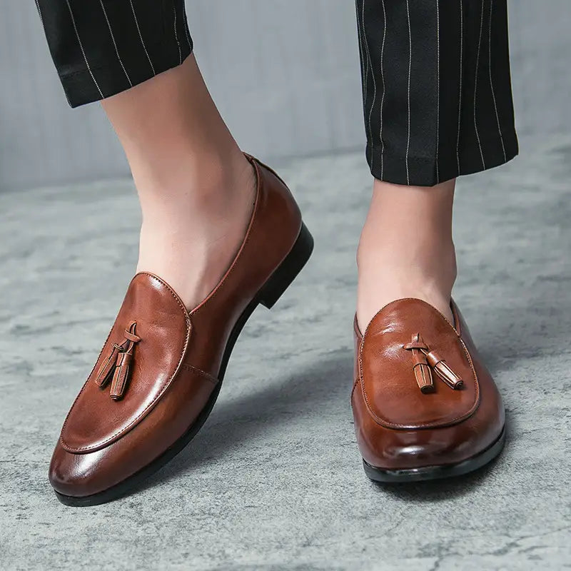 Mocassins à glands en cuir brun avec une finition polie et un design classique sans lacets, issus de la collection de mocassins en cuir à glands britanniques pour jeunes hommes.