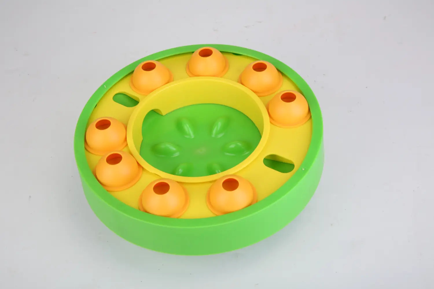 Dog-Puzzle-Futterspielzeug mit langsamer Fütterung als interaktives Spielzeug aus leuchtend grünem und gelbem Kunststoff, mit orangefarbenen gewölbten Fächern für anregende Fütterungsrunden.