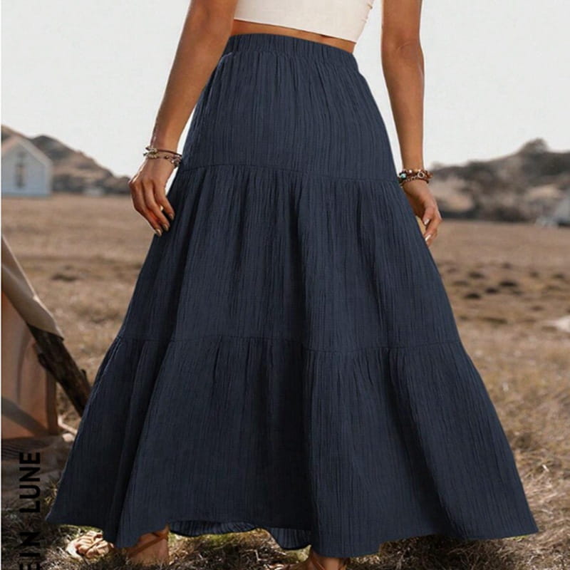 Navy blue tiered maxi skirt with button front, lightweight fabric, gathered waist, and subtle vertical pleats designed for casual wear.