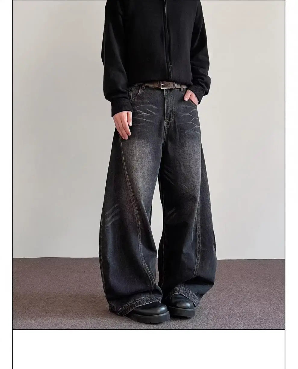 Men’s premium relaxed wide leg denim jeans in black with a faded distressed look and visible stitching details.
