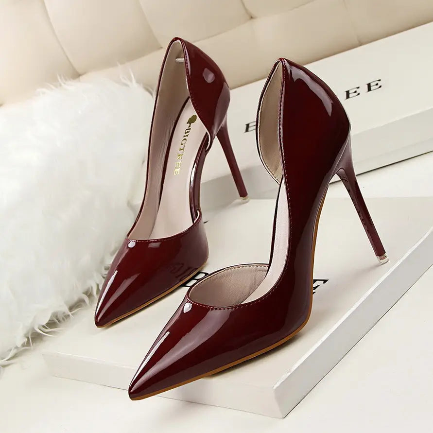 Burgundy patent leather pointed toe stiletto high heels featuring a thin heel.