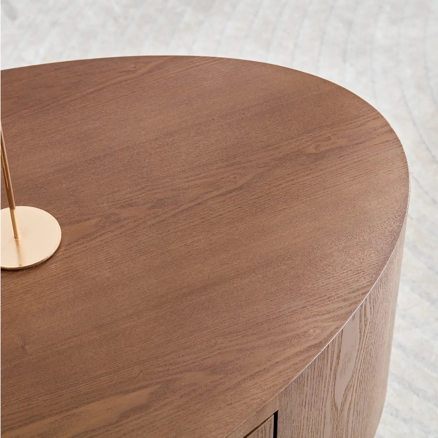 Ein eleganter oval geformter Couchtisch aus dunklem Nussbaumholz mit sichtbarer Maserung und integriertem Stauraum, der keinen Aufbau erfordert.