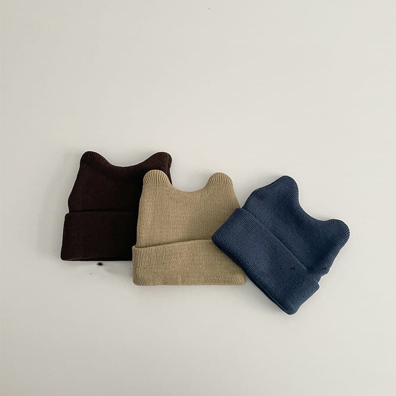 three childrens knitted beanie hats in dark brown beige and navy blue with a soft ribbed texture and rounded ear-like protrusions for warm winter use