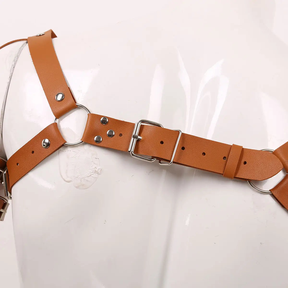 Men’s leather chest harness in tan leather with adjustable straps featuring silver-toned metal buckles and studs.