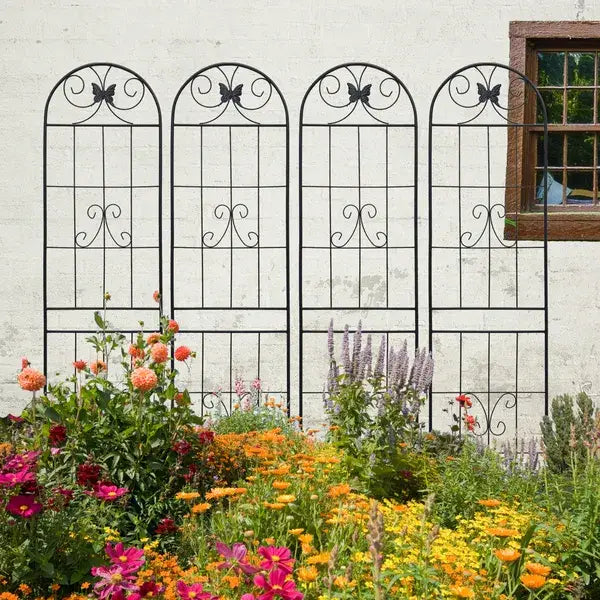 Four black wrought iron garden trellises with arched tops and butterfly motifs shown as a metal garden trellis 4 pack 87 inch butterfly arched black.