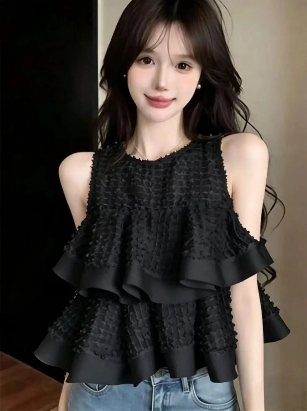 Blusa negra sin mangas con volante fruncido y detalle de volante en capas elaborado con tejido entretejido con textura.