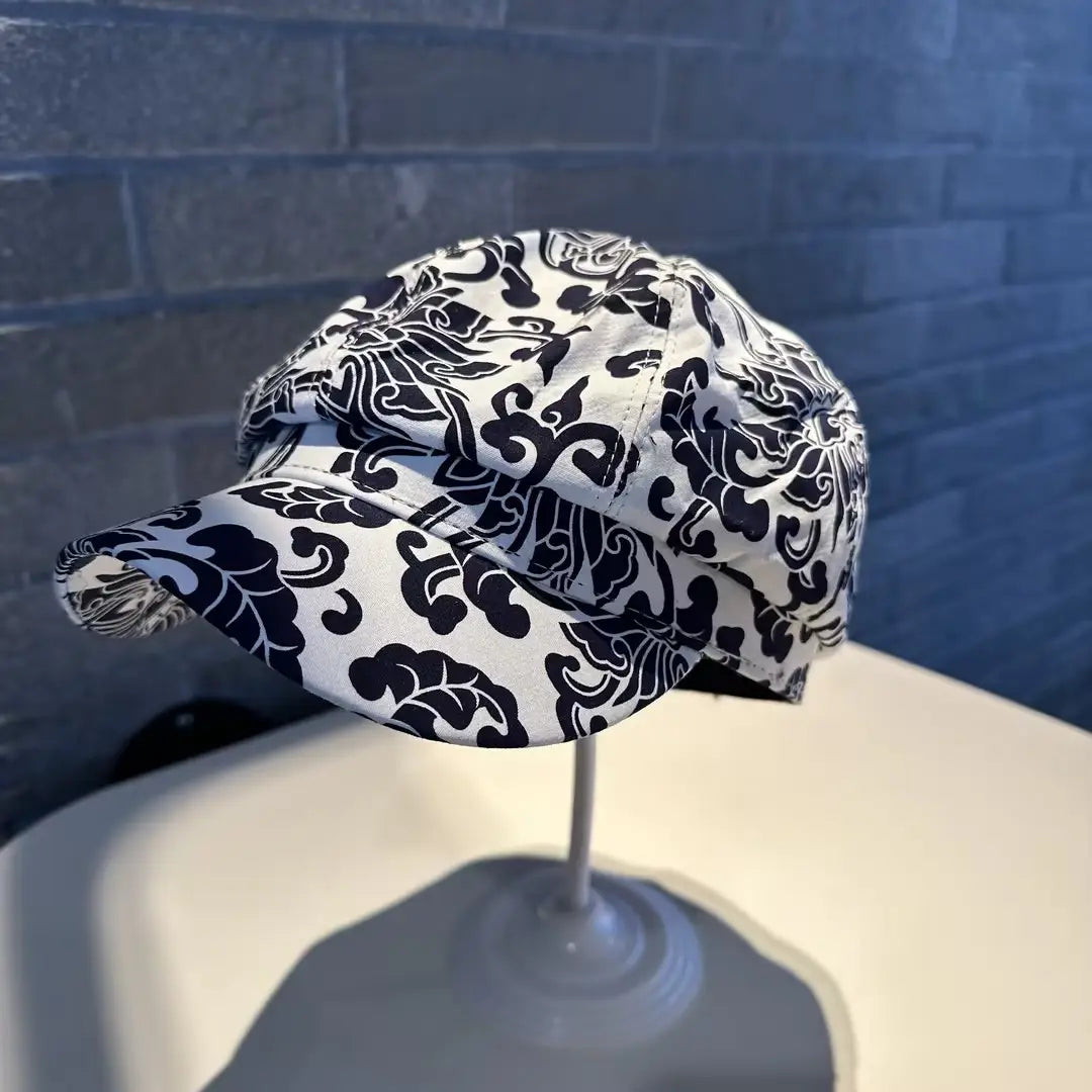 A stylish black and white floral newsboy cap for women crafted from soft fabric with intricate patterned designs.