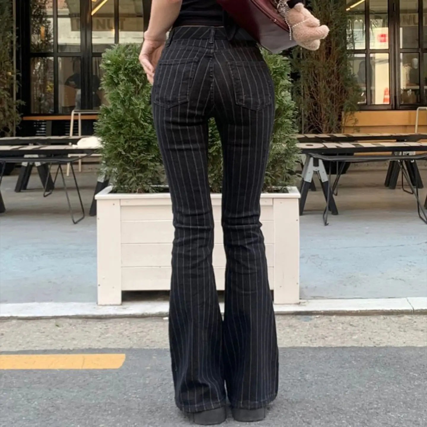 Schwarze Pinstripe-Schlagjeans mit niedrigem Bund und dezenten vertikalen Streifen im Denim-Material.