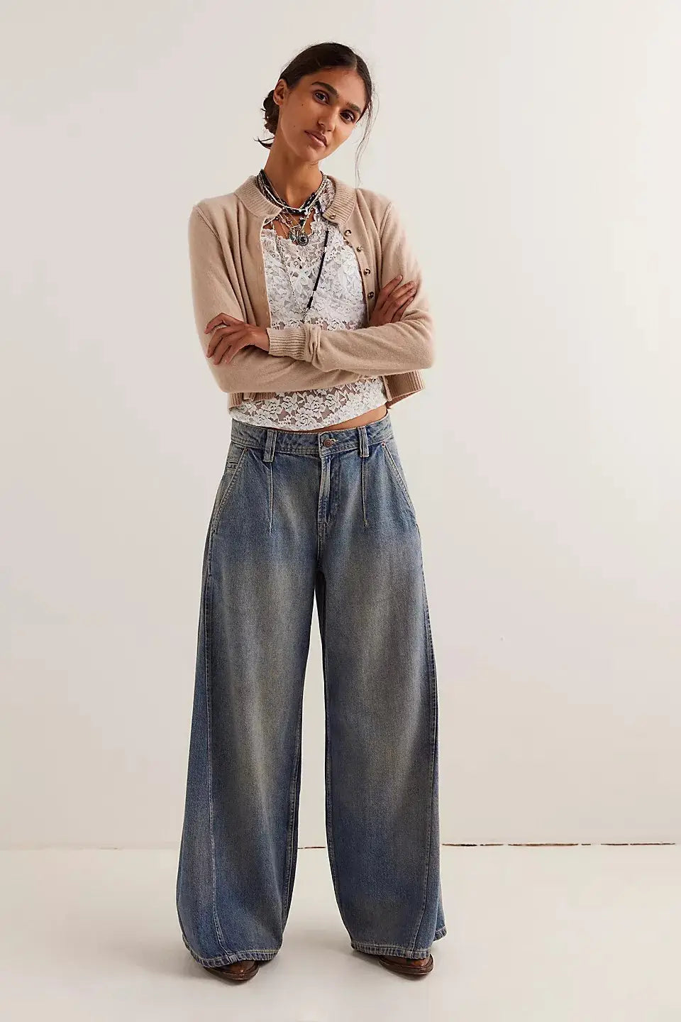 Vaqueros retro de mezclilla de pierna ancha en azul vintage con cintura alta y parte delantera plisada en un lavado azul descolorido.