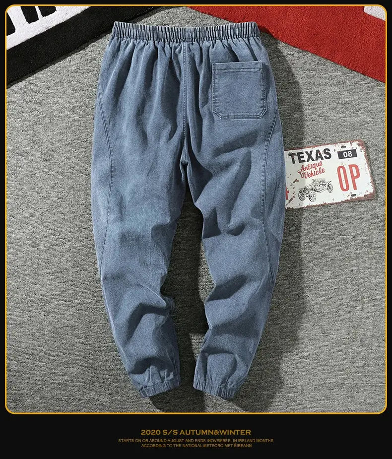 Men’s relaxed fit denim joggers in light wash with elastic waistband and drawstring featuring cuffed hems and a comfortable fit.