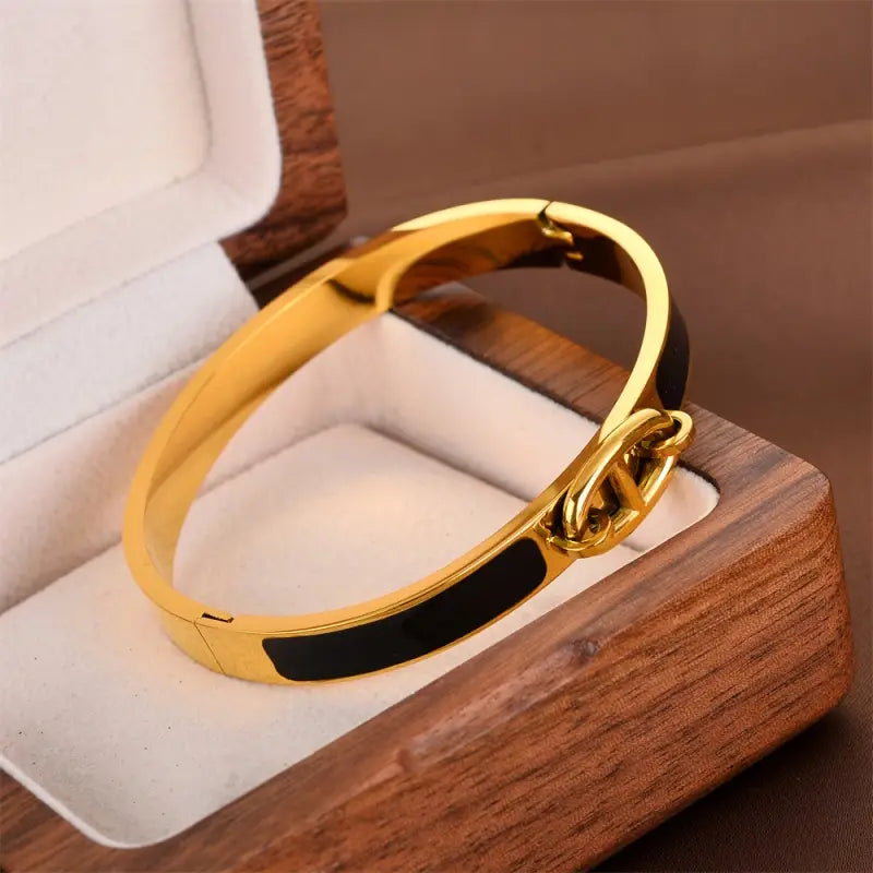 Women h bangle gold enamel minimalist bracelet with a gold-tone polished finish and bold black interlocking double c logo inlay, a stylish bangle fashion bracelet.