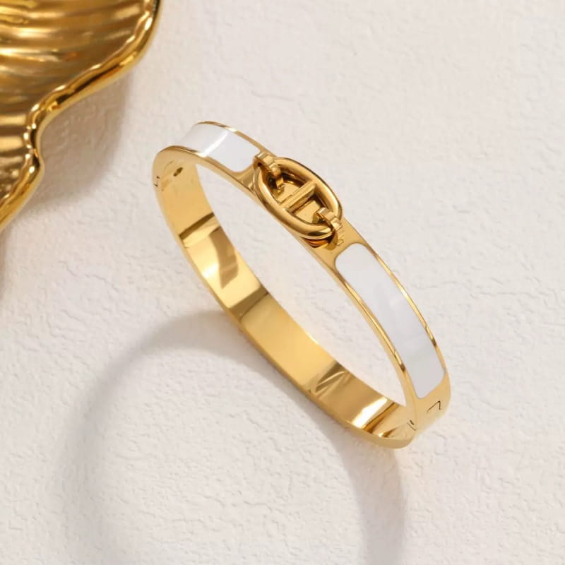 Women h bangle gold enamel minimalist fashion bracelet featuring a gold-toned sleek design with two horizontal white enamel stripes and a central interlocking chain clasp.