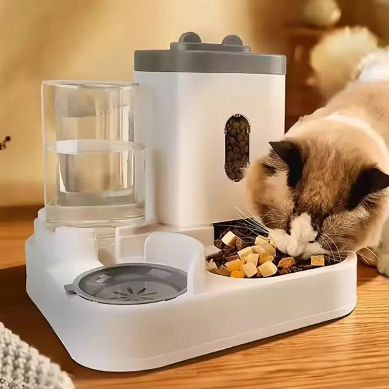Automatic dog bowl and water dispenser in white and gray with a transparent water reservoir and a food compartment filled with kibble featuring a sleek modern design.