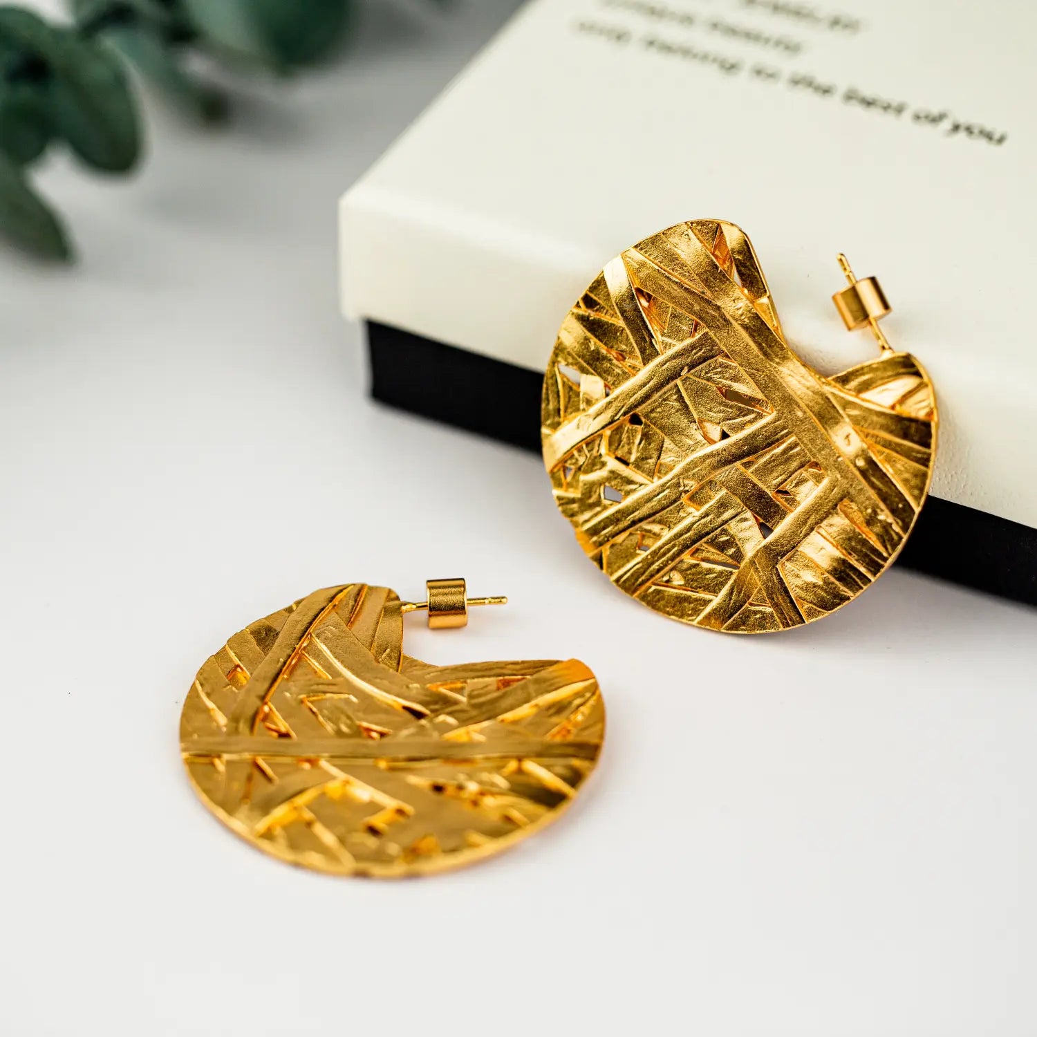 Ohrringe mit abstraktem Tropfen-Design, vergoldet mit 24k Gold, mit goldfarbenen blattförmigen Hoops mit einem fein strukturierten, verflochtenen Muster und metallischem Finish.