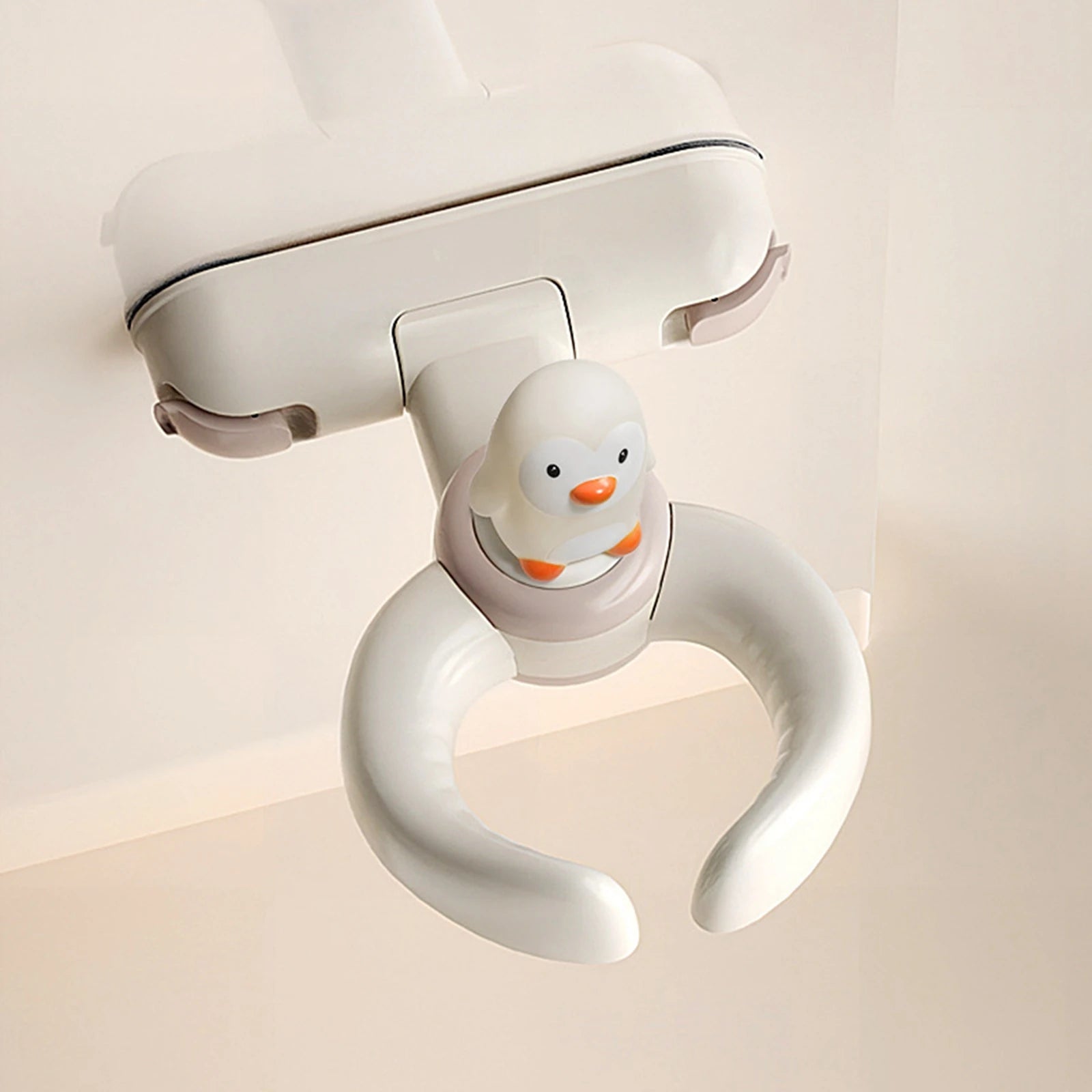 Weiße Pinguin-Thema-Babysicherheitsklammer mit orangefarbenem Schnabel und Füßen zur Sicherung von Kinderwagen oder Babyschalen, ausgelegt als Baby-Badewannen-Badehilfe mit Saugnapf.