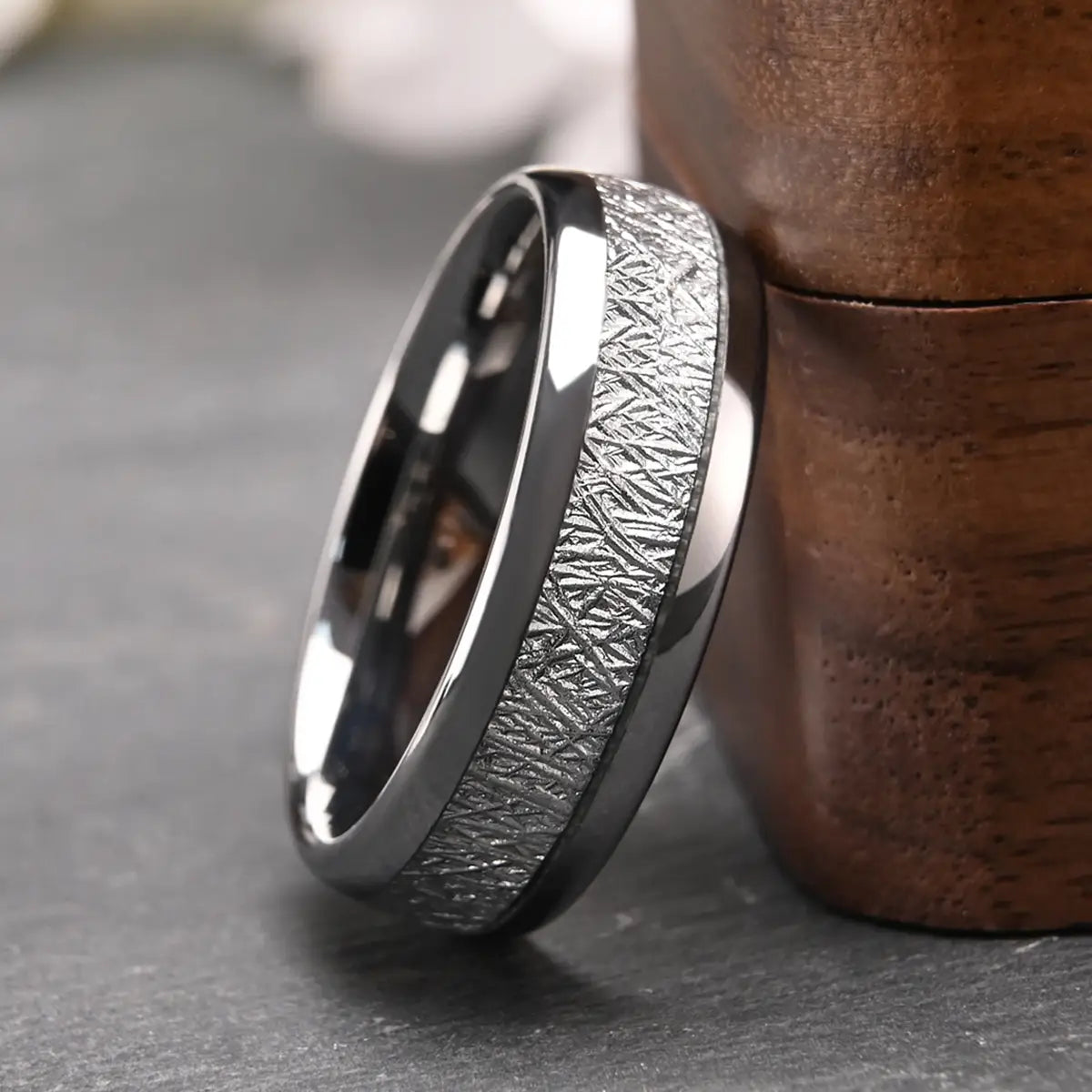 質感のあるシルバー調の隕石インレイを備えた、洗練された黒いタングステンのメンズ結婚指輪。
